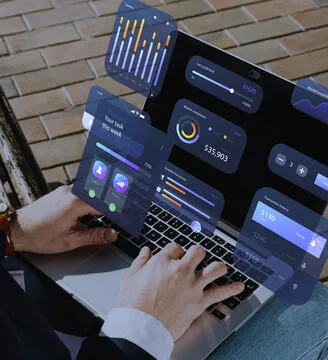 hands on a laptop with its screen showing graphs and stats