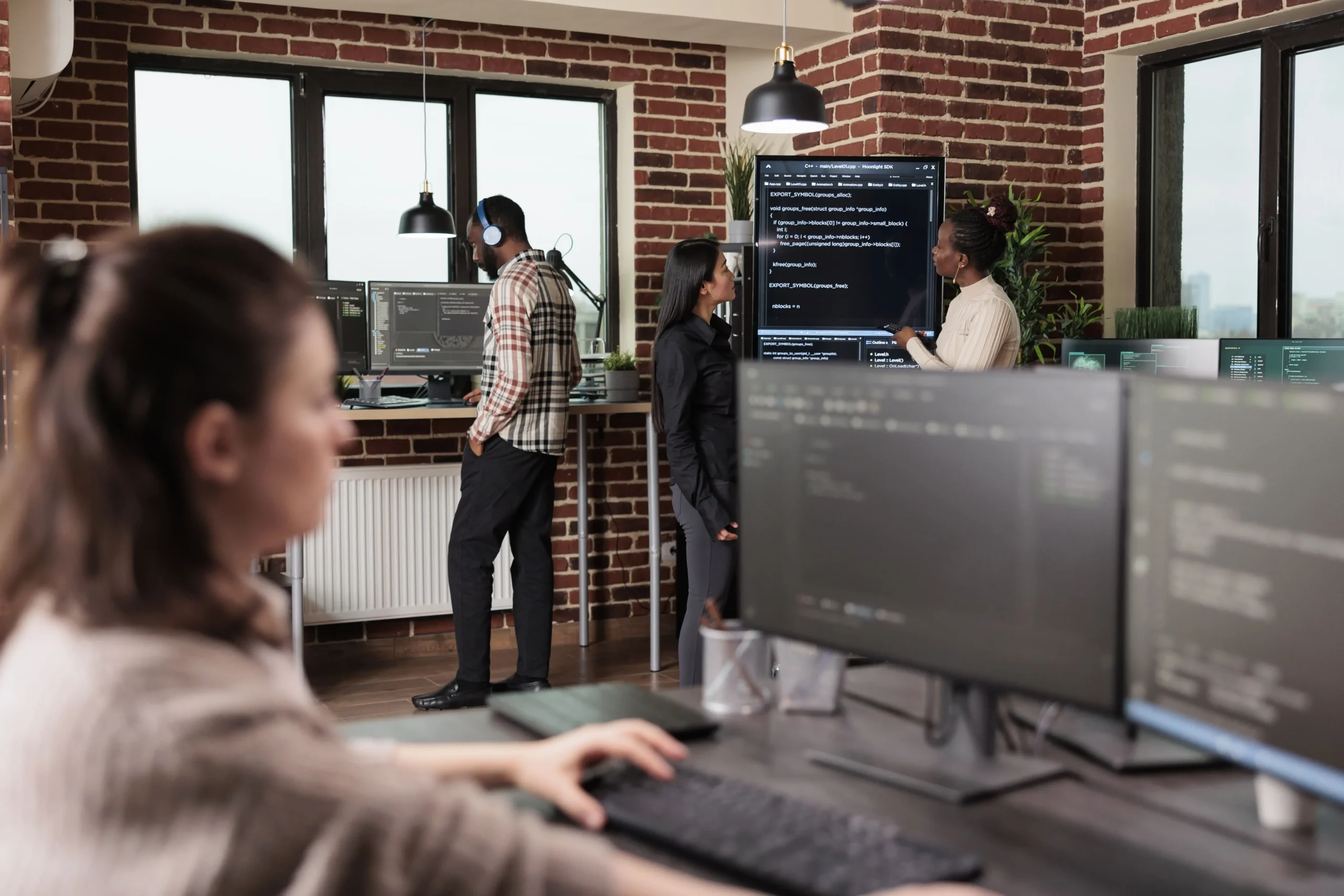 three member of a web development team are working on their tasks at different tables